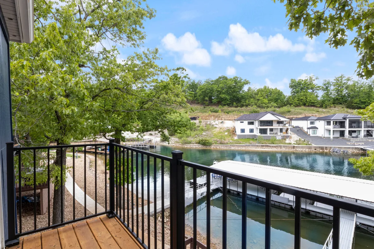A peaceful balcony view overlooking the marina and lush greenery, with railings framing the scene. The area appears serene, with water, trees, and the marina offering a natural backdrop perfect for morning walks or unwinding after outdoor adventures.
