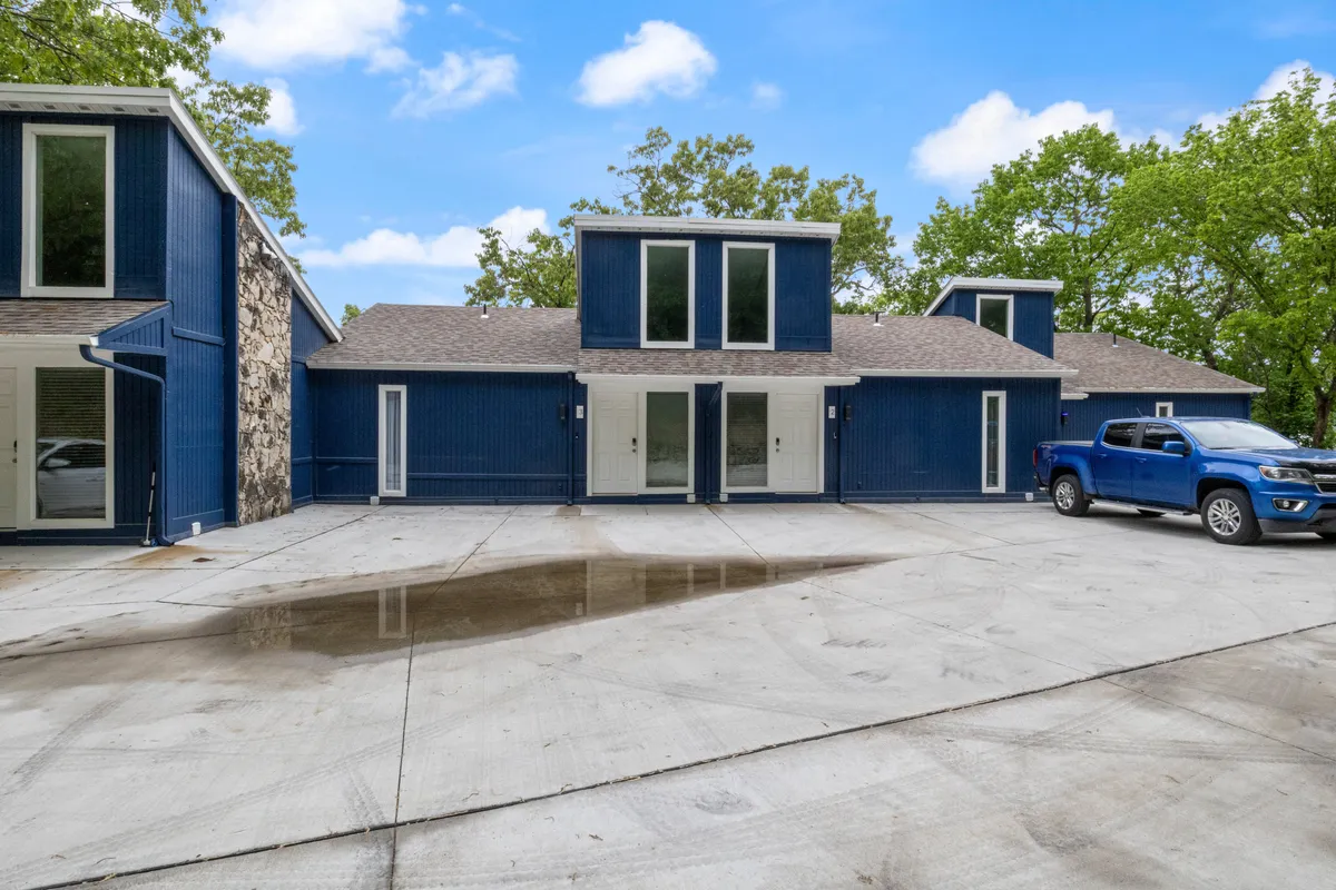The blue exterior of the house is highlighted by large windows and a stone facade, with cars in the driveway and space for outdoor gatherings. The home’s welcoming look promises comfort and a launching point for exploring nearby attractions.